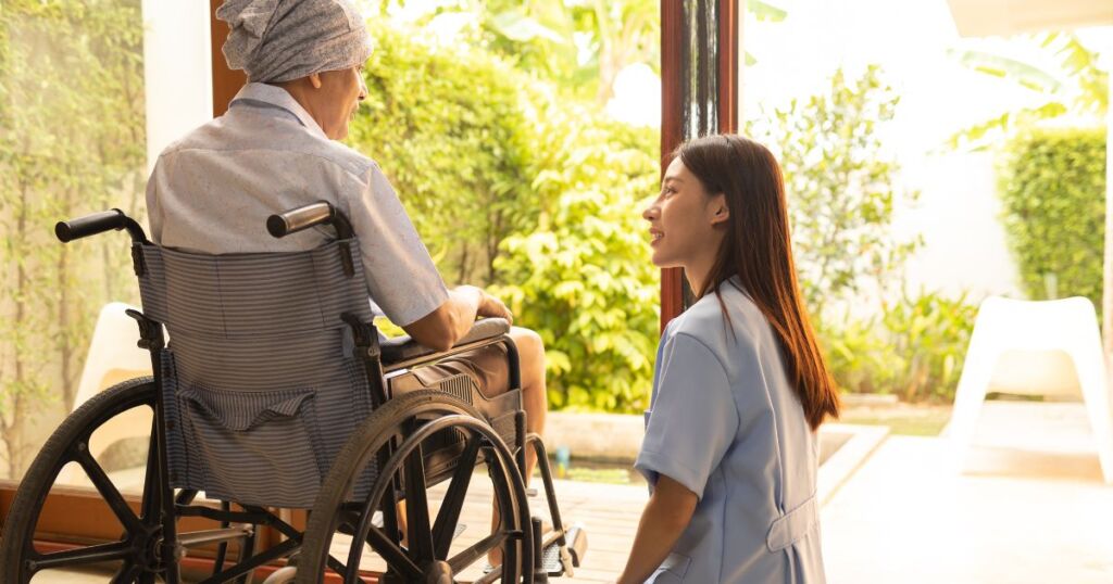 woman helping elder patient on wheelchair